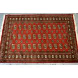 Pakistan rug of Turkoman design with three rows of gols on red ground with borders, 182cms x 124cms