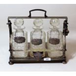 Silver plated three bottle tantalus with cut glass bottles, and three silver decanter labels