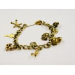 9ct Gold curb link charm bracelet with various charms, 24g