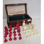 19th Century natural and red stained bone chess set, height of king 10.5cms, height of pawn 4cms, in