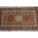 Small Indo Persian rug with a triple medallion design on a green ground with borders, 149cms x 89cms