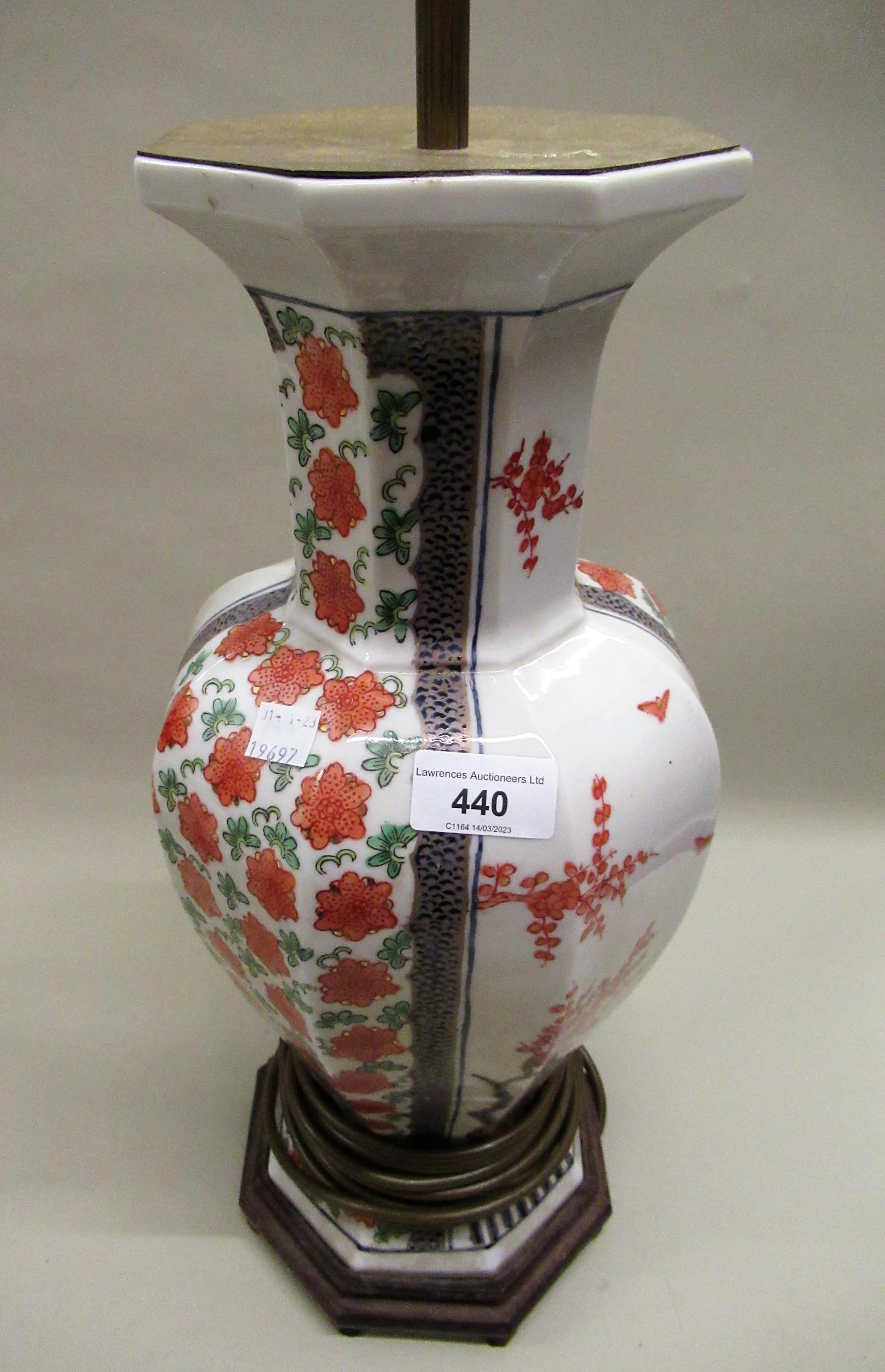 20th Century oriental octagonal baluster form vase, with floral decoration on hardwood stand,