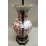 20th Century oriental octagonal baluster form vase, with floral decoration on hardwood stand,