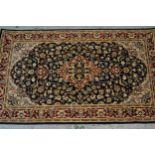 Small Pakistan rug of Persian design with a medallion and floral all-over pattern on a navy ground