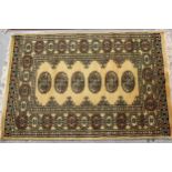 Small Pakistan Bokhara design rug with a single row of gols on a beige ground, 194cms x 65cms