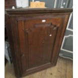 18th Century oak hanging corner cabinet, the moulded cornice above an arched fielded panel door