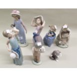 Group of five Lladro figures of young girls and a cat (one at fault), and two smaller Nao figures of