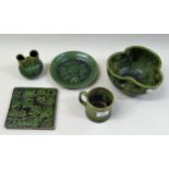 Five pieces of Farnham pottery green glazed items including an owl decorated bowl, a tile and