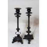 Pair of patinated bronze candlesticks on tripod claw supports, 30cms high