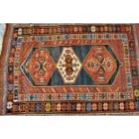 Kazak rug with a triple medallion design on a blue ground with multiple borders, 170cms x 120cms