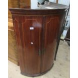 George III oak and inlaid two door bow front hanging corner cabinet, 107.5cms high