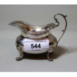 Small London silver cream jug with C-scroll handle on low cabriole supports