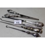Four silver handled buttonhooks and a pair of silver handled glove stretchers
