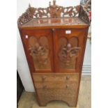 Burmese carved hardwood narrow side cabinet, the galleried top above two doors, with applied figural