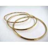 Three various 14ct gold bangles, two plain and one of spiral twist design, 14g