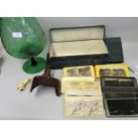 Stereo viewer with various cards and a large green glass, with a figure of a mouse and a cat