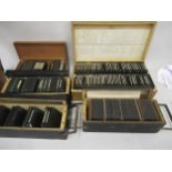 Five wooden boxes containing a collection of various glass magic lantern slides including views of