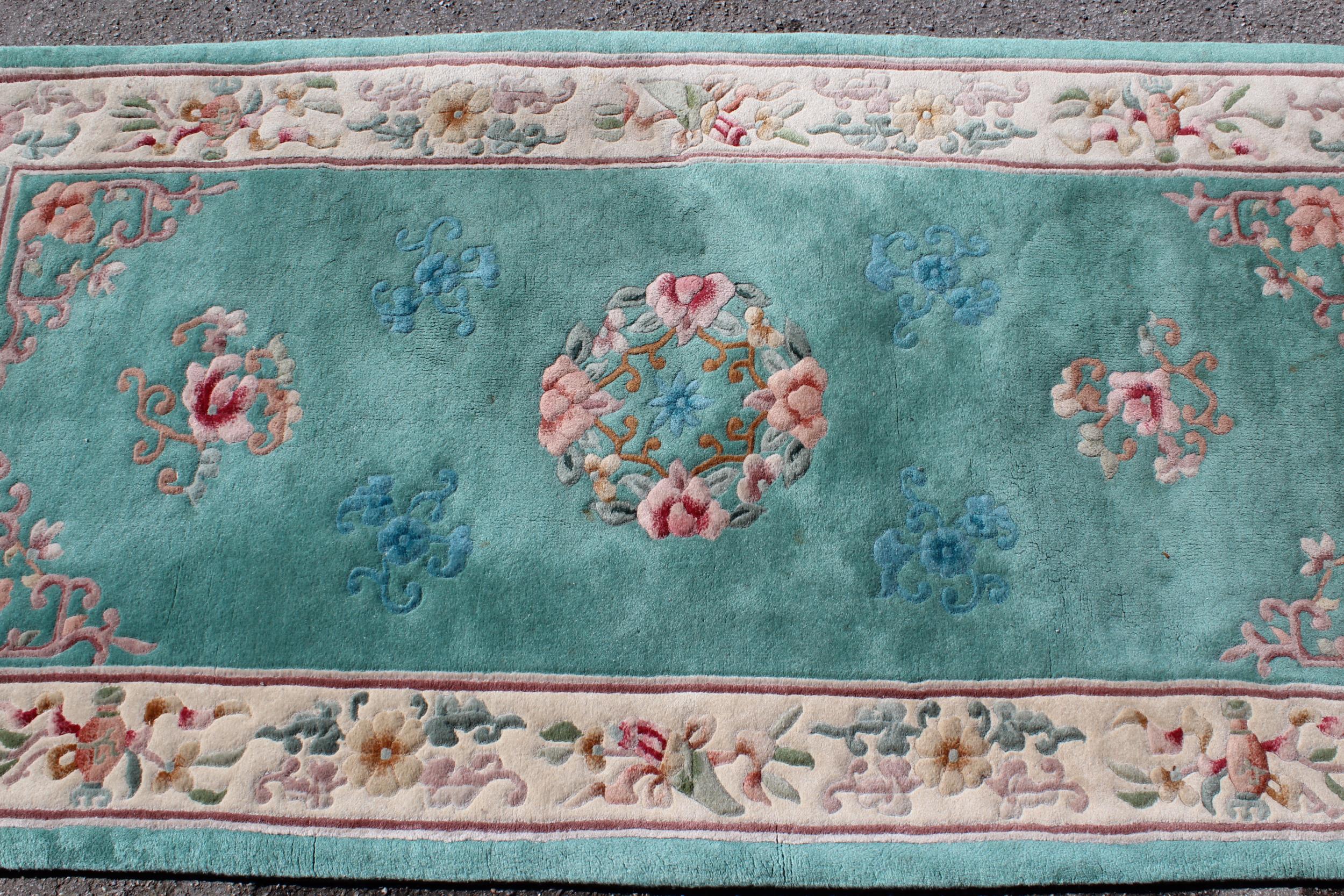 Modern rectangular Chinese rug with all-over floral design and borders on a green ground, 93cms x
