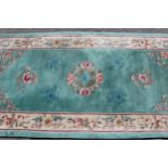 Modern rectangular Chinese rug with all-over floral design and borders on a green ground, 93cms x