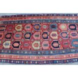 Kazak runner with an all-over stylised design on a brick red ground with borders, 250cms x 108cms