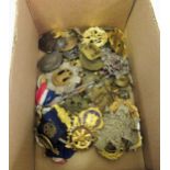 Small box containing a collection of various military badges, buttons and other badges, including