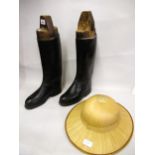 Pair of black leather riding boots with wooden trees together with an oriental straw hat