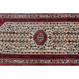 Small 20th Century Belouch style rug with a medallion and all-over design on an ivory ground with