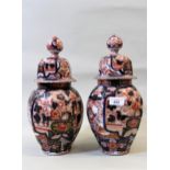 Pair of 19th Century Imari octagonal baluster form vases with covers, 36cms high One finial off
