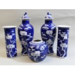 Pair of 19th Century Chinese blue and white baluster form vases with covers decorated with prunus