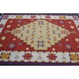 Modern Kelim carpet of geometric design on brick red ground, approximately 9ft x 6ft