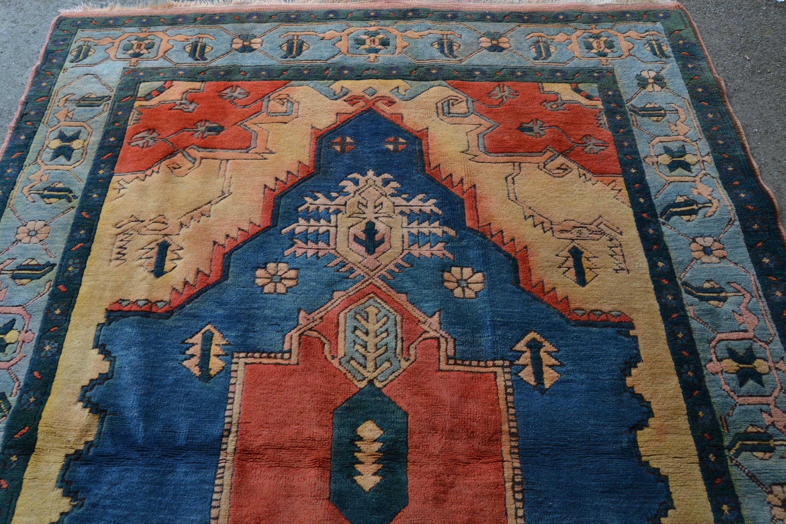 Turkish carpet with a large lobed medallion design in shades of terracotta and blue and beige, - Image 3 of 3