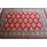 Pakistan rug of Turkoman design with three rows of gols on a red ground with borders, 192cms x