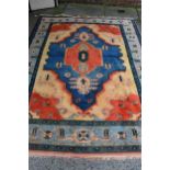 Turkish carpet with a large lobed medallion design in shades of terracotta and blue and beige,