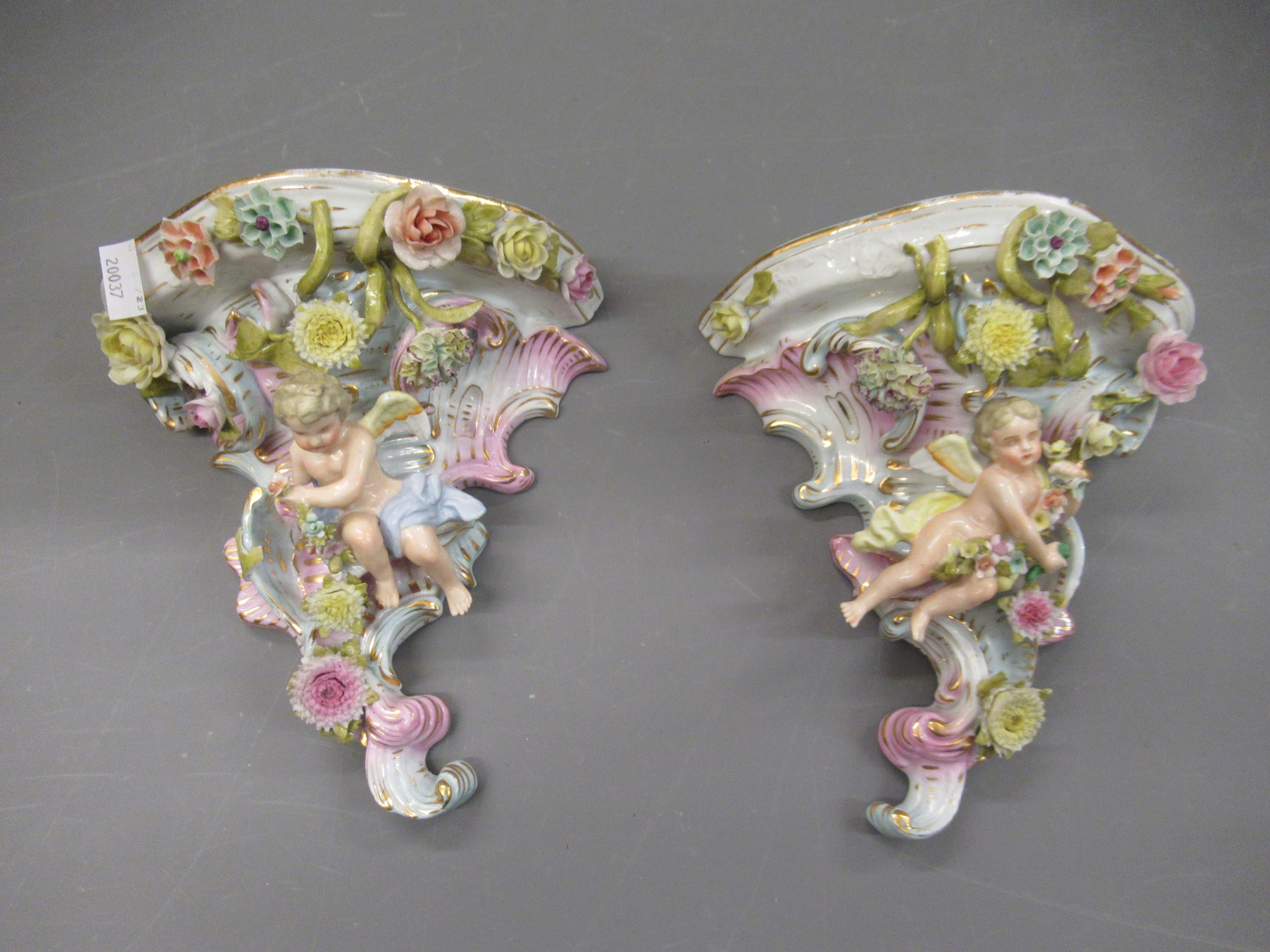 Pair of late 19th Century Continental porcelain wall brackets with floral and cherub decoration