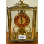 Triangular gilt brass three hundred day clock, 23cms high