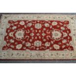 Small Indo Persian rug of Ziegler design, with a red ground and ivory borders, 160cms x 96cms