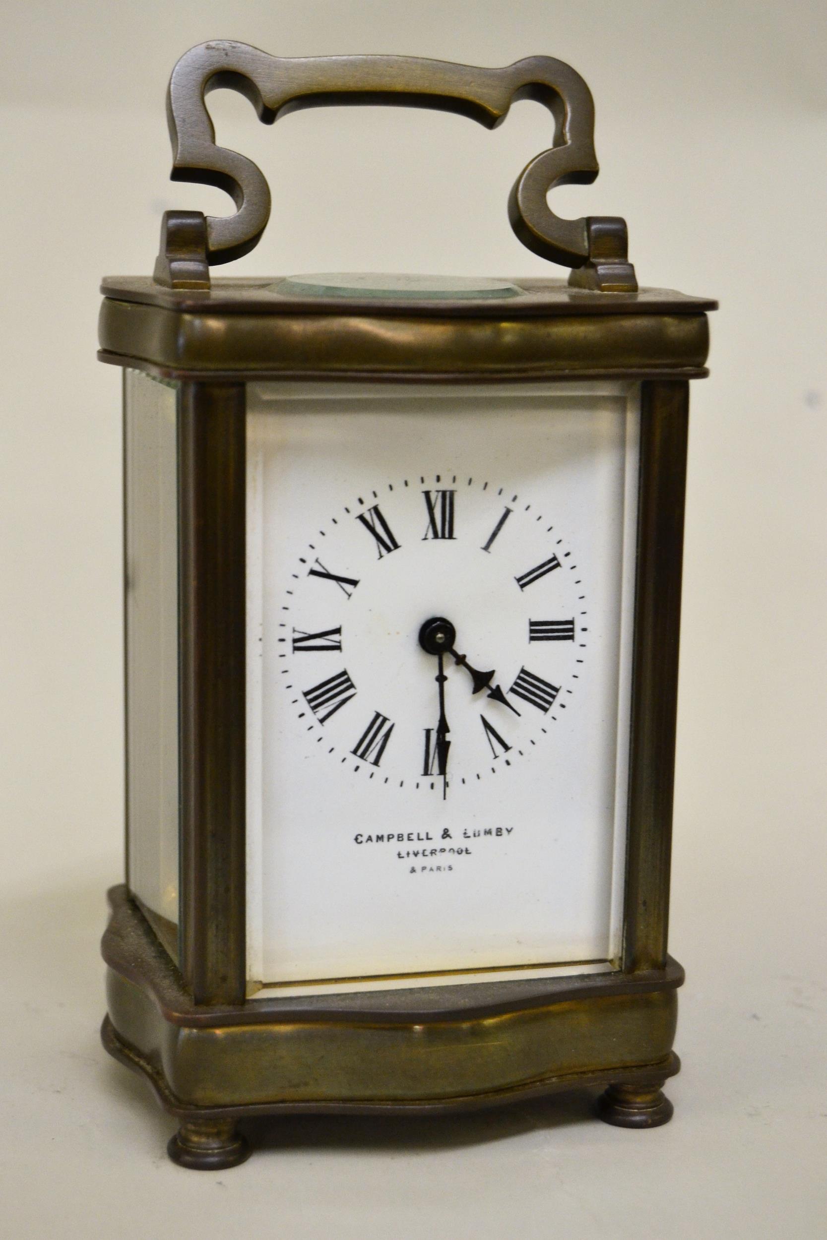 Small brass cased carriage clock, the enamel dial with Roman numerals, signed Campbell & Lumby,