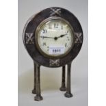 Pewter circular cased mantel clock of stylised form, with circular enamel dial having Arabic