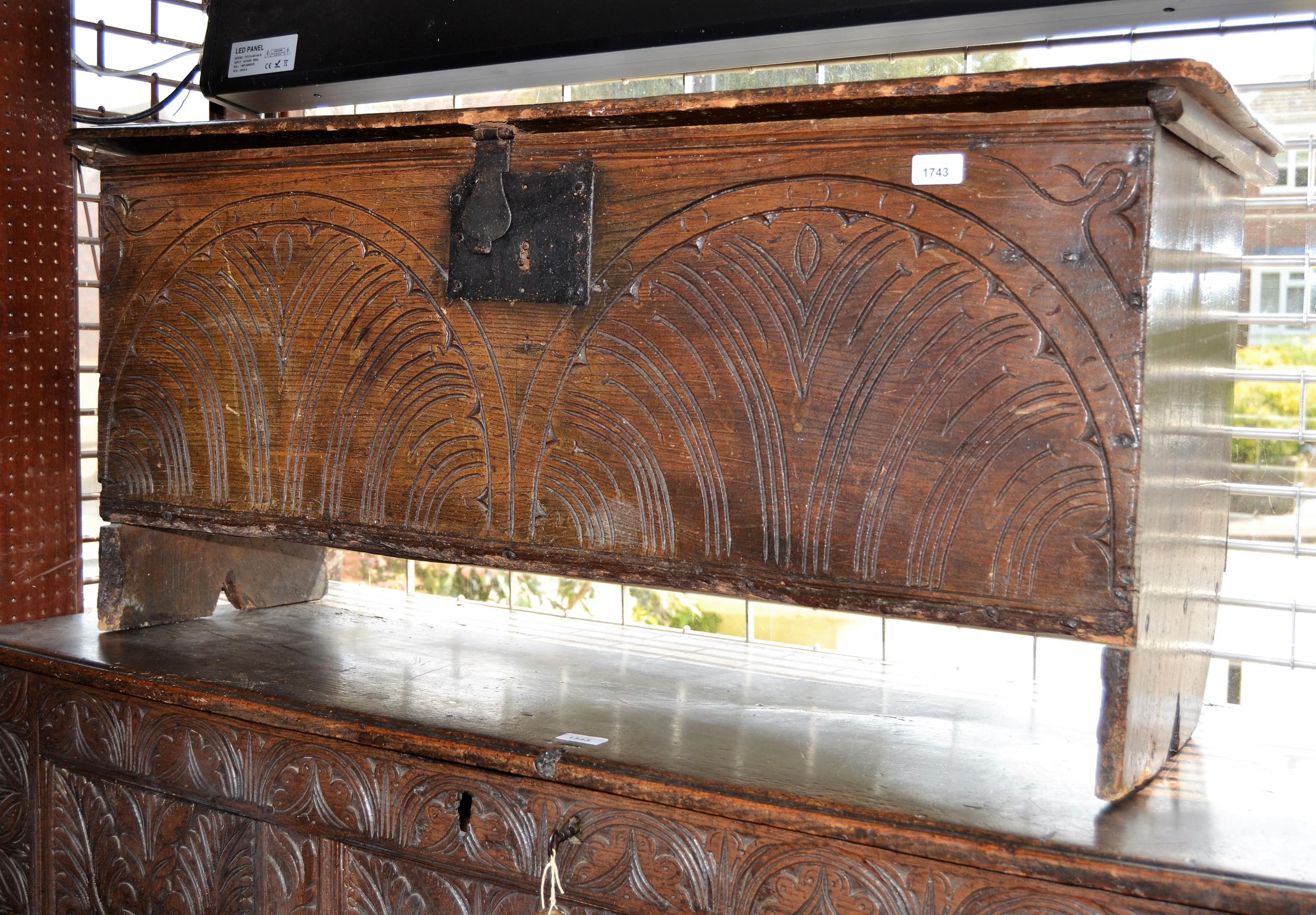 17th Century oak plank coffer, the moulded lid above a carved front with iron hasp and staple on