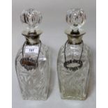 Pair of square cut glass decanters with silver collars and silver decanter labels
