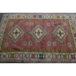 Modern Turkish rug with a triple medallion design on a rose ground with borders, 180cms x 120cms