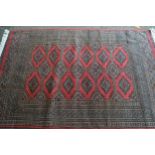 Pakistan rug of Bokhara design with two rows of gols on a rose ground with multiple border, 180cms x