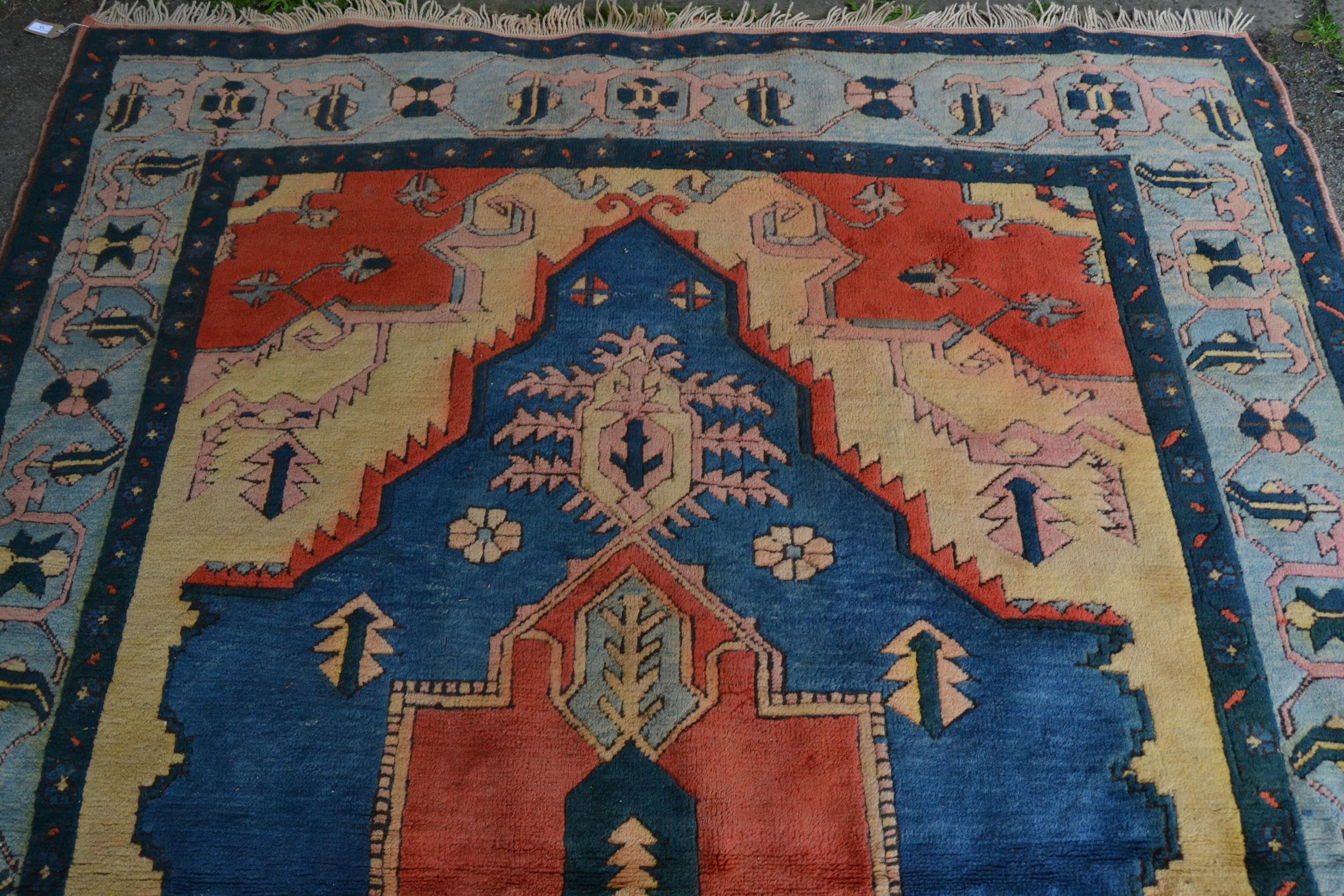 Turkish carpet with a large lobed medallion design in shades of terracotta and blue and beige, - Image 2 of 3