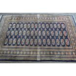 Pakistan rug of Turkoman design with three rows of gols on a blue ground with borders (various