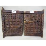 Two African native carved hardwood grain store doors, each 28cms x 20cms approximately