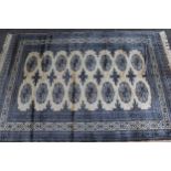 Pakistan rug of Turkoman design with two rows of eight gols on a pale pink ground with borders,