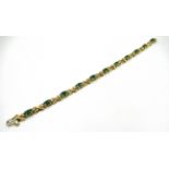 18ct Yellow gold emerald and diamond line bracelet set with eleven oval emeralds and twenty two