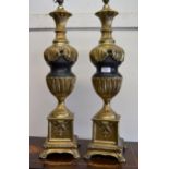 Pair of large cast gilded brass and black patinated table lamps, 68cms high Are a little loose,