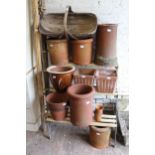 Quantity of terracotta chimney pot tops and garden planters, together with a wooden trug