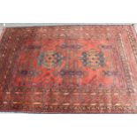 Afghan rug with a twin medallion design on a rust ground with multiple borders, 190cms x 130cms